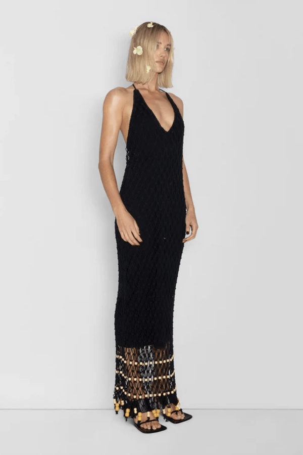 Reis Macrame Maxi Dress Noir by The Wolf Gang – Striking handmade black macrame dress with beaded hem, ideal for festivals or summer soirées.