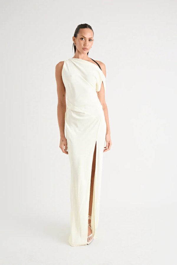 Matia Gown Butter by Pfeiffer – A timeless maxi with a boat neckline, low back, and adjustable strap. Perfect for elegant events and special occasions.