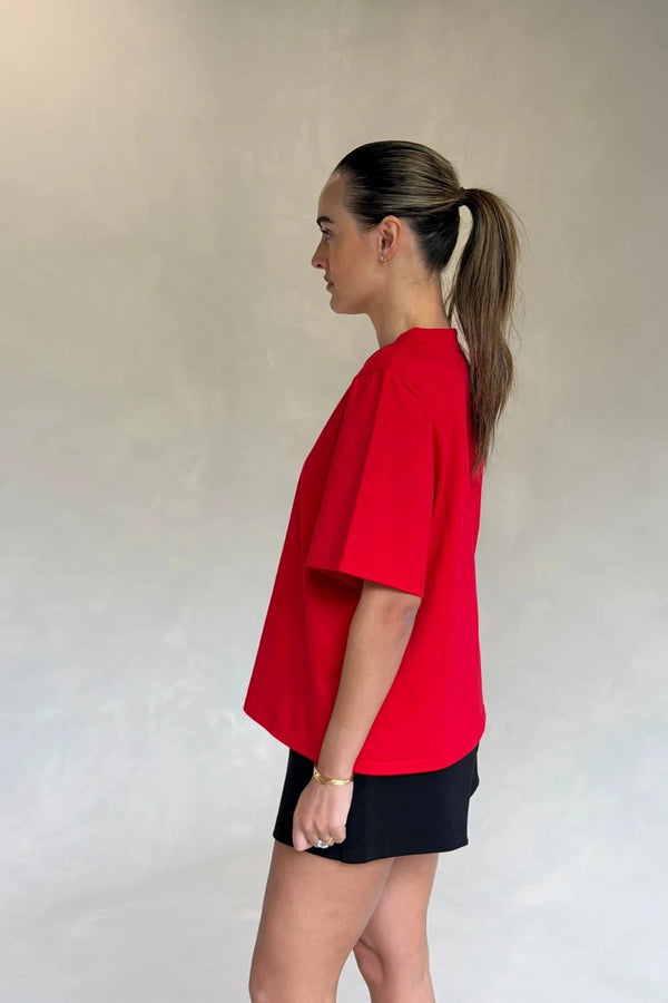 Red Olivia High V Neck Relaxed Tee with short sleeves and a loose fit on a plain background.