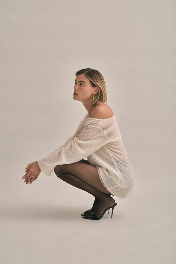 The Eloise Beaded Mini Ivory by Solaqua – sheer beaded mini dress with off shoulder neckline and oversized fit.