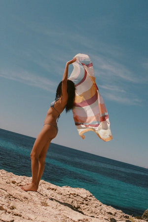 Square Pareo in Iris by Soleil Soleil , a versatile organic cotton wrap or scarf with rainbow-hued stripes, perfect for relaxed resort days.