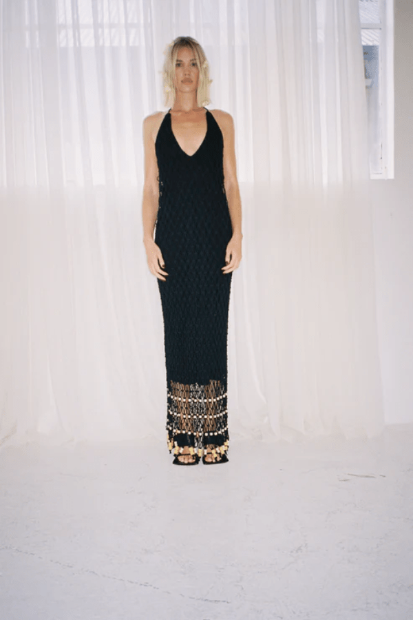 Reis Macrame Maxi Dress Noir by The Wolf Gang – Striking handmade black macrame dress with beaded hem, ideal for festivals or summer soirées.