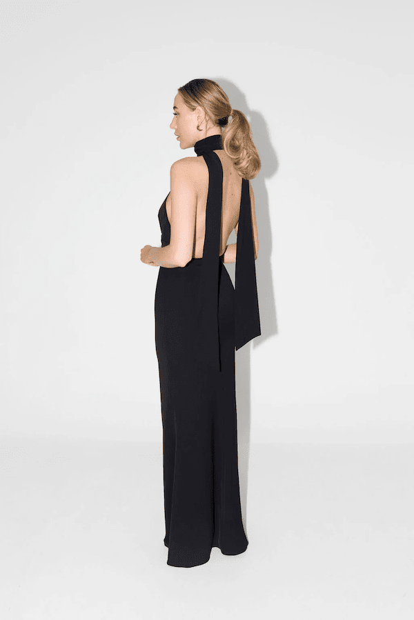 The Ultimate Muse Tie Neck Maxi Dress Black by Odd Muse – A trendy maxi with a romantic V-neckline, draped shoulders, and low back, perfect for bridal parties and elegant celebrations.