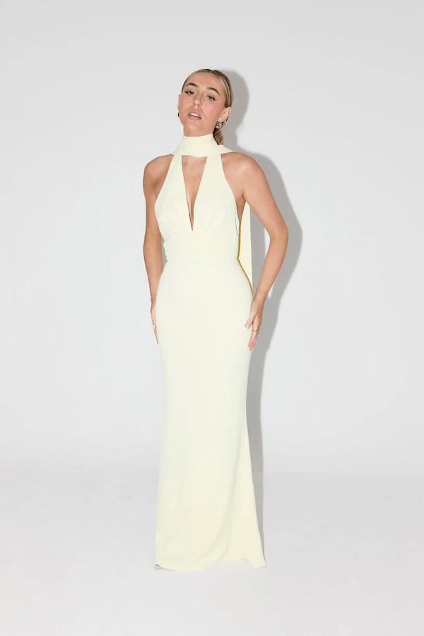 The Ultimate Muse Tie Neck Maxi Dress Butter Cream by Odd Muse – A viral bridal favorite featuring a flattering V-neck, draped shoulders, and elegant low back, perfect for all-night celebrations.