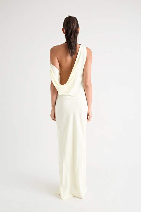 Matia Gown Butter by Pfeiffer – A timeless maxi with a boat neckline, low back, and adjustable strap. Perfect for elegant events and special occasions.