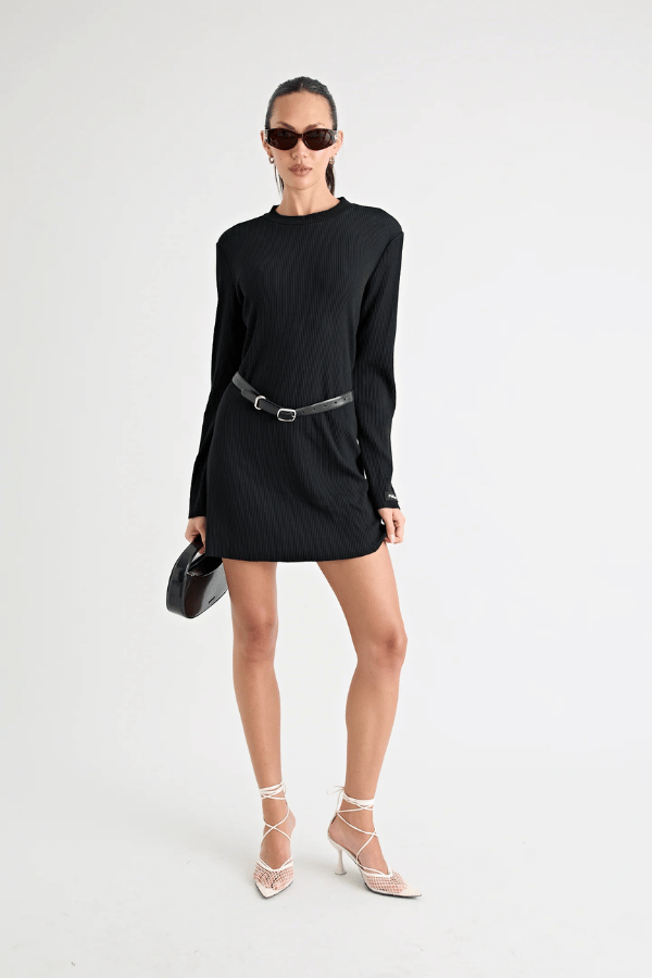 Fairbank Rib Dress Black by Pfeiffer – A trendy, comfortable ribbed bamboo dress with high raw-edge neckline, full sleeves, and versatile two-part back design. Perfect for chic casual wear or layering in cooler seasons.