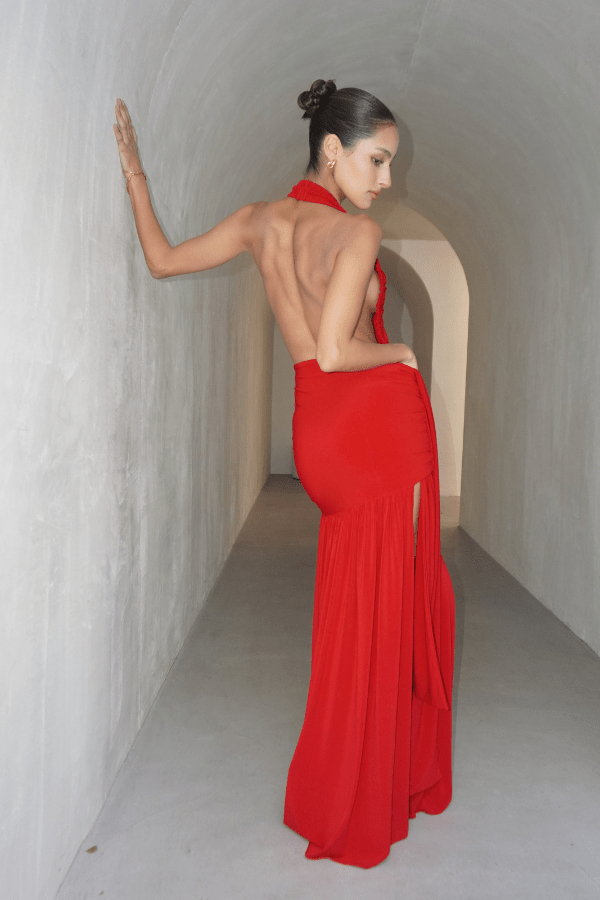 Dakota Pure Red by Deconduarte – Trendy fluid jersey dress with elastic neckline, fitted belt skirt, side slit, and lettuce-edge hem, perfect for confident, carefree occasions.