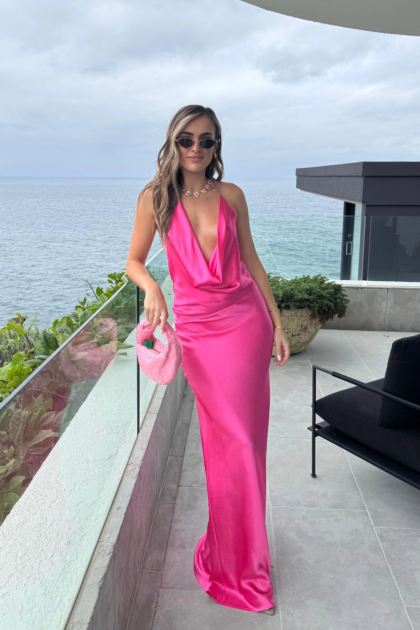 Gabi Gown Neon Pink by Natalie Rolt – A vibrant, bias-cut silk gown with dramatic open back and adjustable ties, perfect for making a trendy statement at special events.
