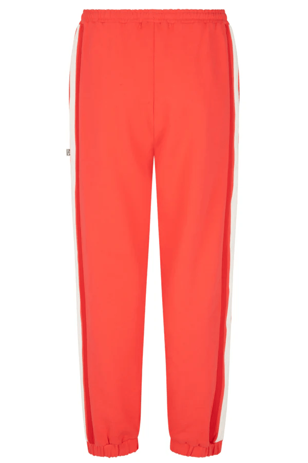 Bisous Trackpant Coral by Araminta James, features a relaxed fit with tapered leg, soft brushed fleece fabric, elasticized waistband with drawcord, side pockets, elastic cuffs, and contrast side trims.