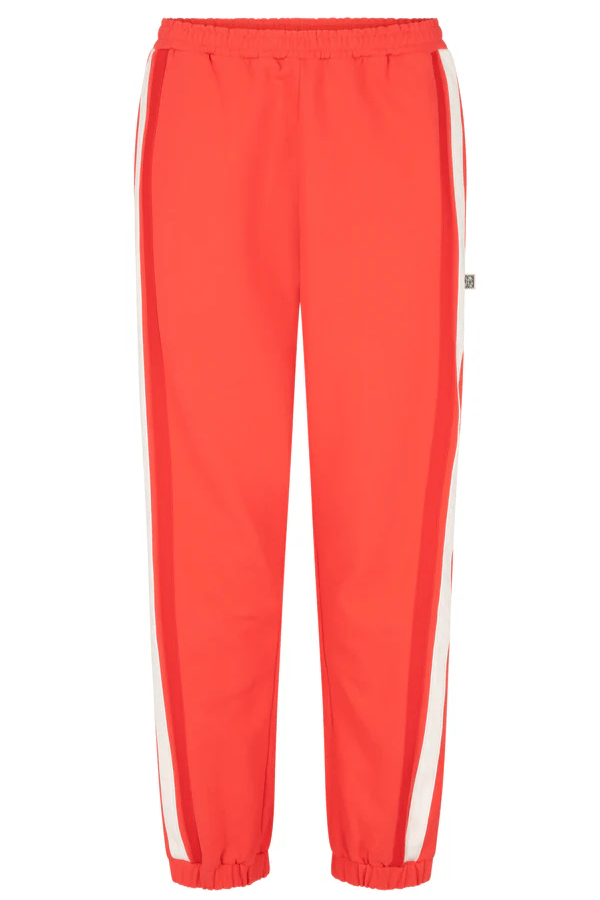 Bisous Trackpant Coral by Araminta James, features a relaxed fit with tapered leg, soft brushed fleece fabric, elasticized waistband with drawcord, side pockets, elastic cuffs, and contrast side trims.