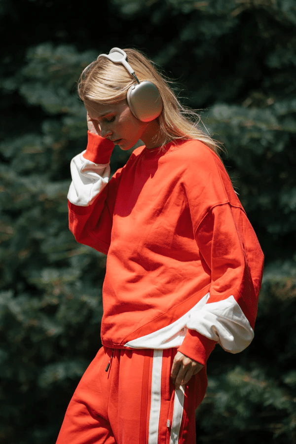 Bisous Trackpant Coral by Araminta James, features a relaxed fit with tapered leg, soft brushed fleece fabric, elasticized waistband with drawcord, side pockets, elastic cuffs, and contrast side trims.