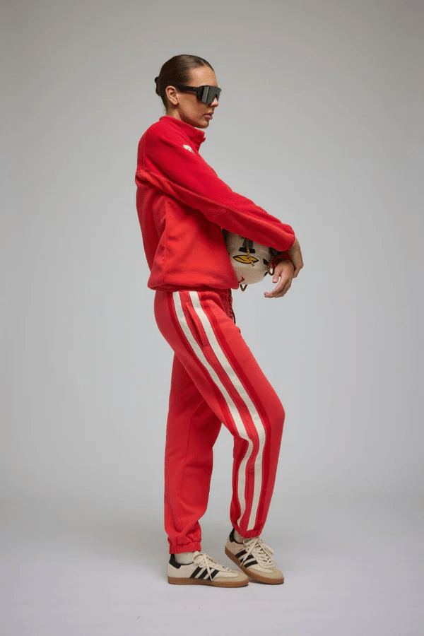 Bisous Trackpant Coral by Araminta James, features a relaxed fit with tapered leg, soft brushed fleece fabric, elasticized waistband with drawcord, side pockets, elastic cuffs, and contrast side trims.