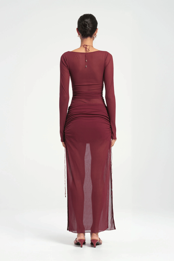 Ari Cutaway Dress Berry by Benni – A trendy maxi with bold geometric cut-outs and sleek long sleeves, perfect for glamorous evenings and statement occasions.