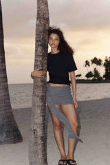 Astra Drape Mini Skirt by Bec + Bridge, a shimmering embellished knit mini with asymmetric gathers and a draped sash—perfect for chic summer styling.