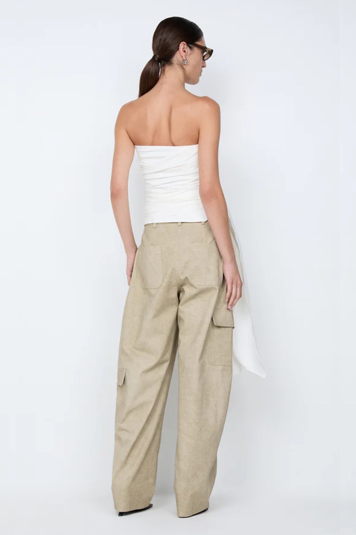 Belle Strapless Top by Bec + Bridge, a sleek nylon silhouette with tucked bodice and front tie detail—perfect for bridal or resort occasions.