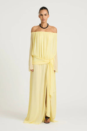 Bernie Maxi Dress by Benni, butter off-shoulder maxi with long sleeves, draped front, waist tie and flowing sheer silhouette.