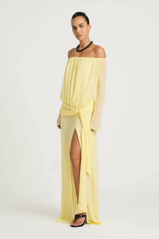 Bernie Maxi Dress by Benni, butter off-shoulder maxi with long sleeves, draped front, waist tie and flowing sheer silhouette.