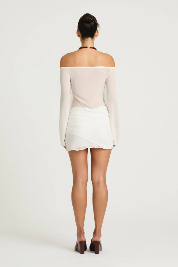 Bernie Mini Dress by Benni, white off-shoulder mini with long sleeves, draped front, waist tie and sheer feminine silhouette.