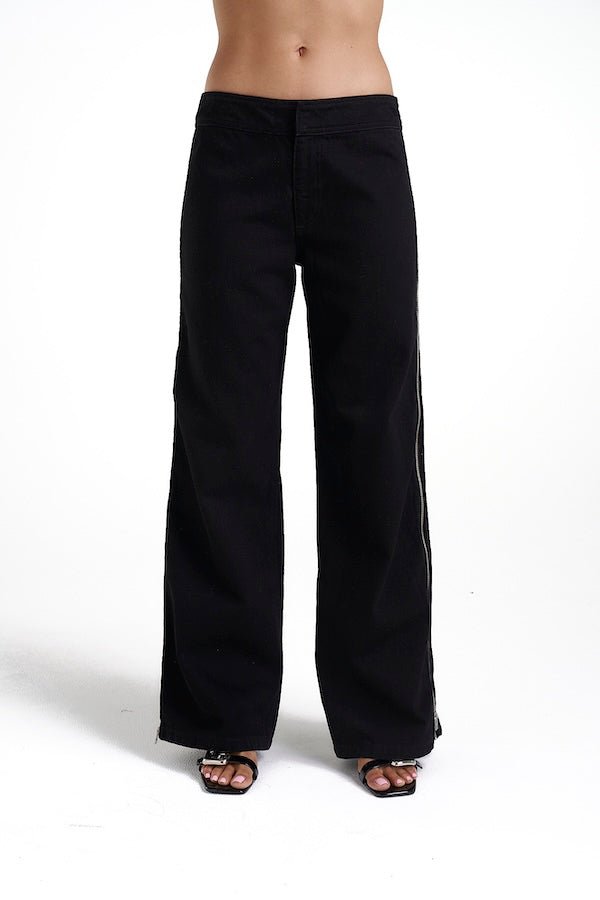 Zip Jeans Black Denim by Summi Summi, trendy mid-rise jeans with a slightly wide-leg design and full-length zippers for a modern edge. Perfect for a relaxed yet stylish look in 100% black cotton denim.