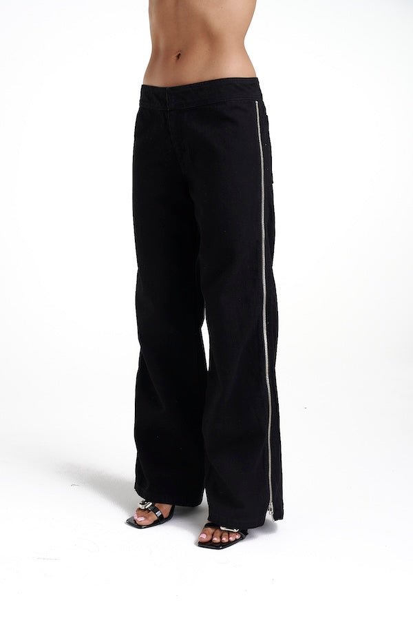 Zip Jeans Black Denim by Summi Summi, trendy mid-rise jeans with a slightly wide-leg design and full-length zippers for a modern edge. Perfect for a relaxed yet stylish look in 100% black cotton denim.