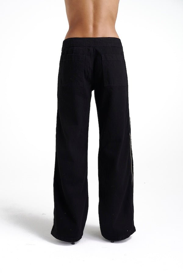 Zip Jeans Black Denim by Summi Summi, trendy mid-rise jeans with a slightly wide-leg design and full-length zippers for a modern edge. Perfect for a relaxed yet stylish look in 100% black cotton denim.