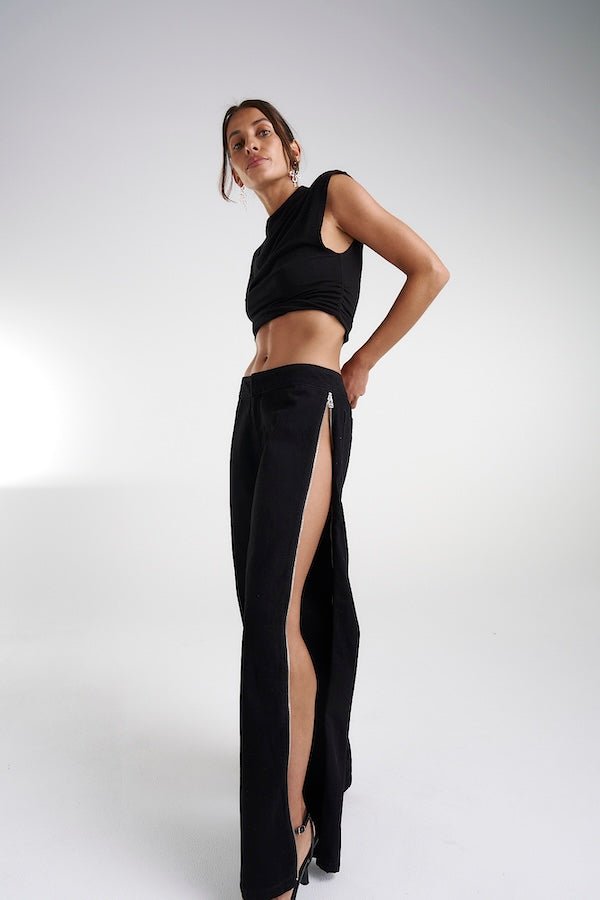 Zip Jeans Black Denim by Summi Summi, trendy mid-rise jeans with a slightly wide-leg design and full-length zippers for a modern edge. Perfect for a relaxed yet stylish look in 100% black cotton denim.