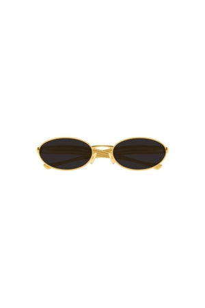 Bottega Veneta BV1386S sunglasses, oval gold frame with sardine-patterned temples and grey lenses. A playful yet chic statement piece.