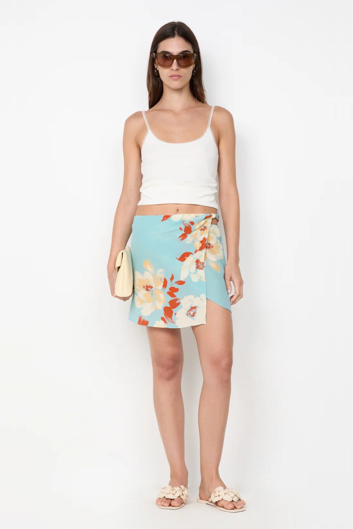 Calliope Mini Skirt by Bec and Bridge — a floral wrap mini with a beaded waist and hip cutout, perfect for polished day-to-night styling.