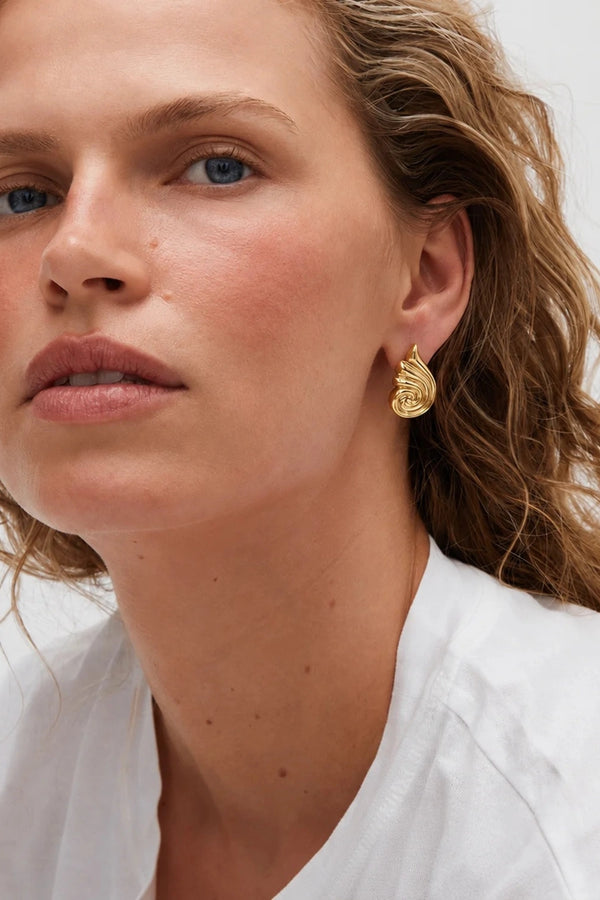 Capri Earrings Gold by Heaven Mayhem – sculptural gold swirl earrings in polished stainless steel.