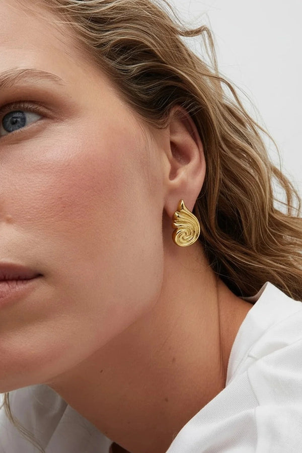 Capri Earrings Gold by Heaven Mayhem – sculptural gold swirl earrings in polished stainless steel.