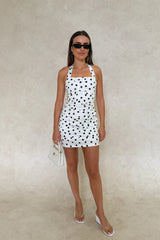 Chrissy Mini Dress White Polka Dot by Sneaky Link – a fitted cotton mini with ruching and tie straps. Perfect for feminine styling.