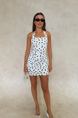 Chrissy Mini Dress White Polka Dot by Sneaky Link – a fitted cotton mini with ruching and tie straps. Perfect for feminine styling.