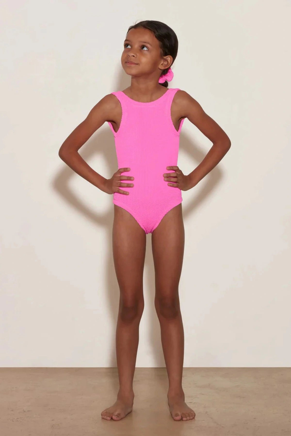 Classic Swim in Bubblegum by Hunza G, a soft crinkle one-piece for ages 3–6. Perfect for twirls, beach days, and playful adventures.