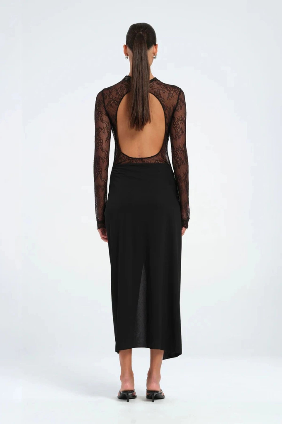 Colton Midi Dress Black by Benni – A trendy high-neck lace dress with open back, built-in bralette, and soft jersey skirt with thigh-high split, perfect for elegant evening occasions.