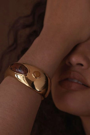 Como Bracelet Gold by Amber Sceats, gold-plated cuff with Red Mahogany and Orange Aventurine, a trendy piece perfect for elegant events or chic layering.