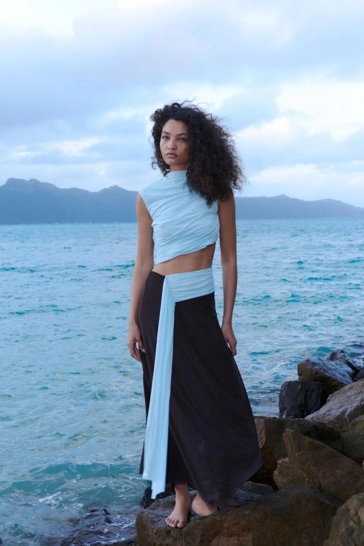 Conni Asym Midi Dress by Bec + Bridge, a two-tone mesh silhouette with cut-out waist, gathered sash, and raw hem for sculptural evening allure.