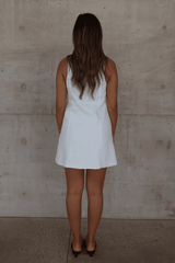 Mia Mini Dress White by Sneaky Link – A trendy, breathable linen dress with a high scoop neckline and button front, perfect for effortless summer days.
