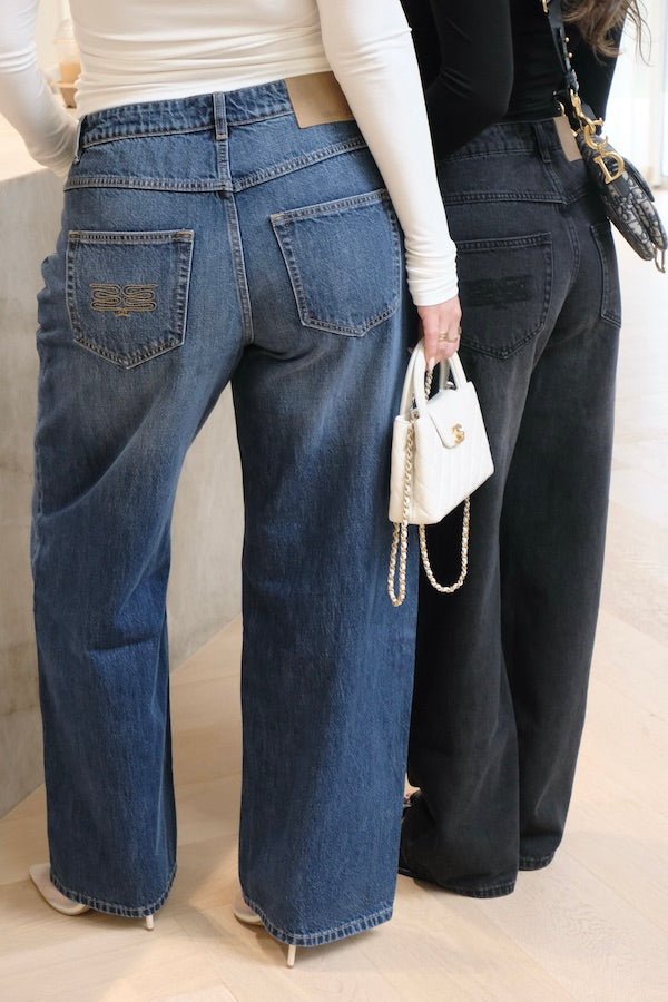 Elisha Baggy Jean Indigo by Sneaky Link, relaxed mid-rise baggy jeans in 100% cotton with branded details. Runs big; size down if unsure.