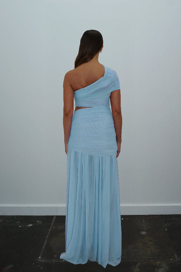 Tiana Dress Baby Blue by DŽO – Trendy one-shoulder sheer mesh maxi with asymmetrical draping, waist cutout, and pleated skirt, perfect for elegant day-to-evening occasions.