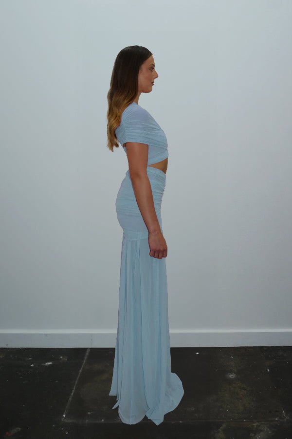 Tiana Dress Baby Blue by DŽO – Trendy one-shoulder sheer mesh maxi with asymmetrical draping, waist cutout, and pleated skirt, perfect for elegant day-to-evening occasions.