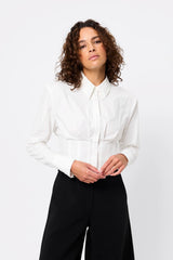 Darcy Shirt in White by Mossman, a structured cropped cotton shirt with shoulder pads and exposed button front.