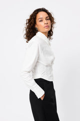 Darcy Shirt in White by Mossman, a structured cropped cotton shirt with shoulder pads and exposed button front.