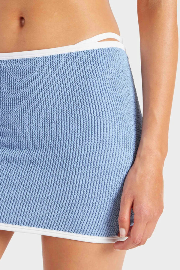 Devyn Swimskirt by Hunza G, a crinkle-textured piece worn as a tube top or skirt. Perfect for beach layering or versatile summer styling.