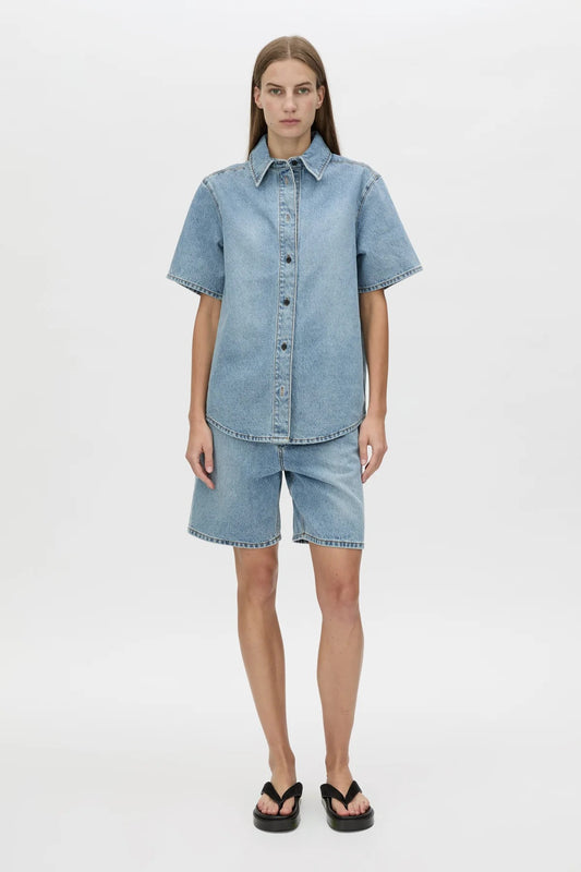 Diego Denim Shirt by Camilla and Marc — a light vintage blue short-sleeve denim shirt with a boxy fit and branded buttons.