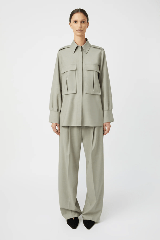 Drew Pant Mottled Stone by Camilla and Marc, tailored low-rise pant with front pleats, fishtail waistband, single arrow belt loops, and back jet pockets with button detail. Crafted in a wool-poly blend with permanent press finish.