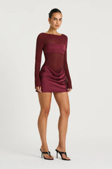 Elvira Mini Dress in Plum by Benni, a sheer stretch mesh mini with long sleeves, satin bralette panel, and draped cowl skirt.