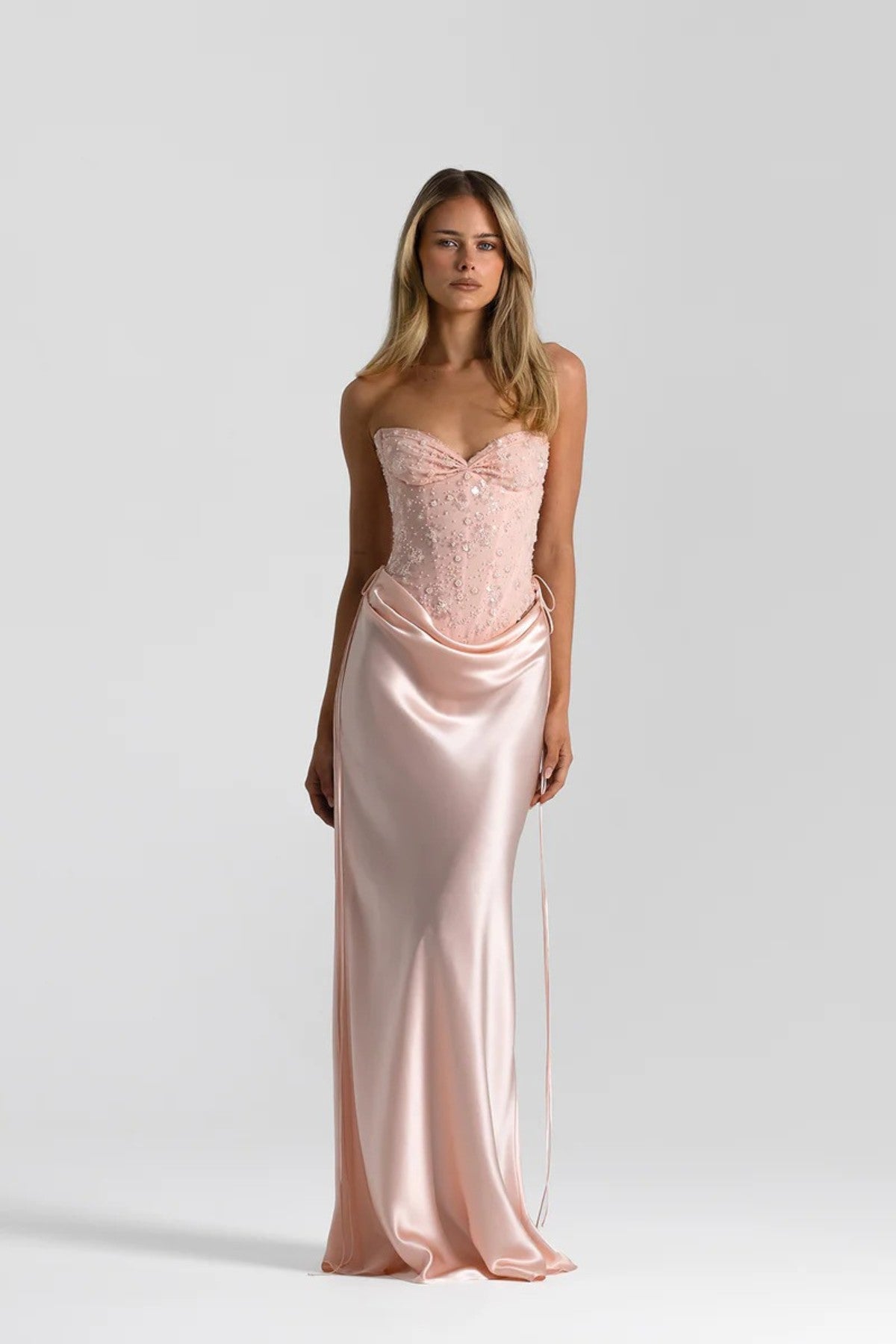 Evelyn Skirt in Baby Pink by Natalie Rolt, a full-length silk design with draped waist and tie accents. Perfect for occasion dressing.