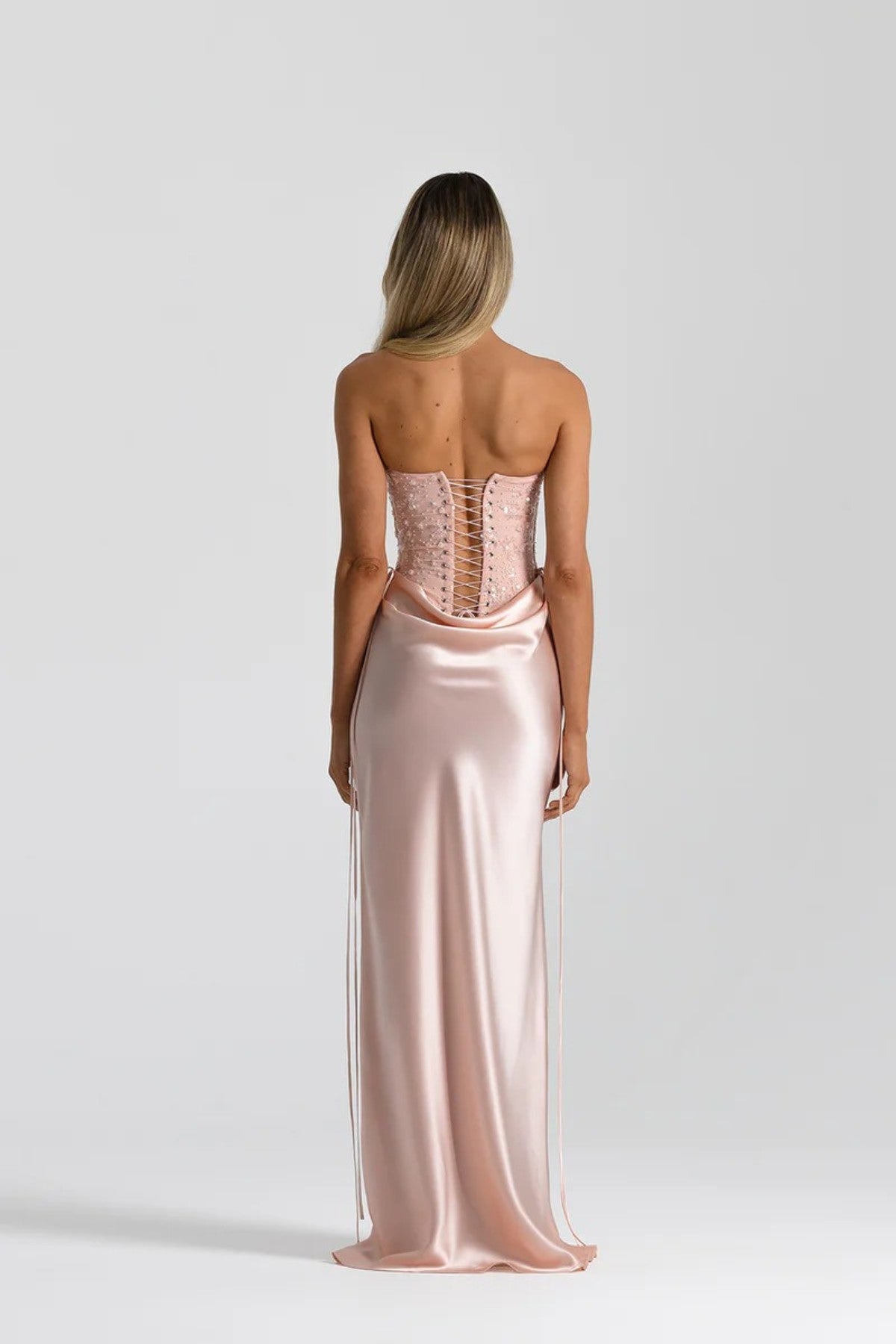 Evelyn Skirt in Baby Pink by Natalie Rolt, a full-length silk design with draped waist and tie accents. Perfect for occasion dressing.