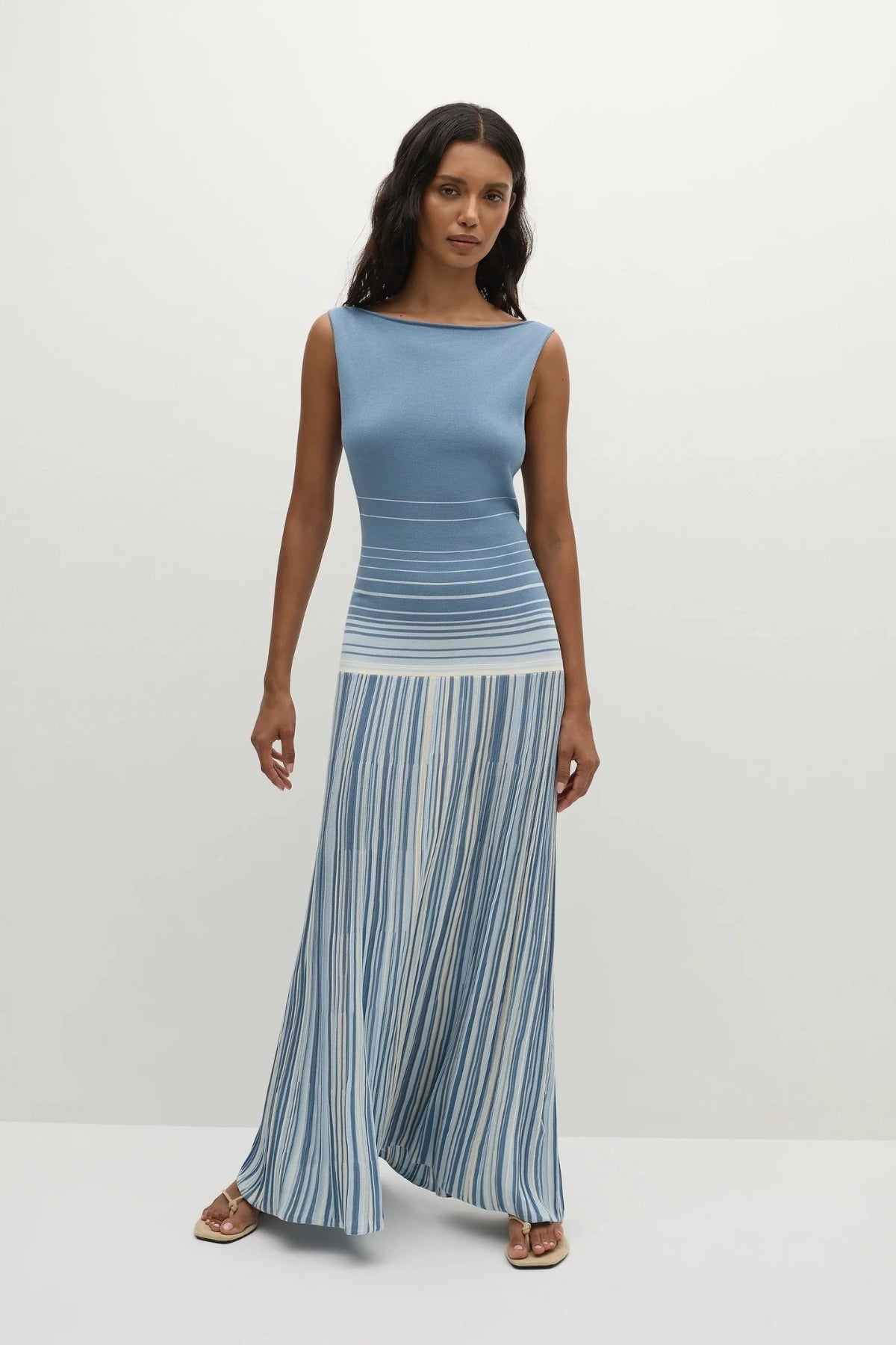 Faithfull the Brand Xyla Maxi Dress in Accordion Stripe Mineral Blue with boat neckline, twist knot back and flared A-line skirt.