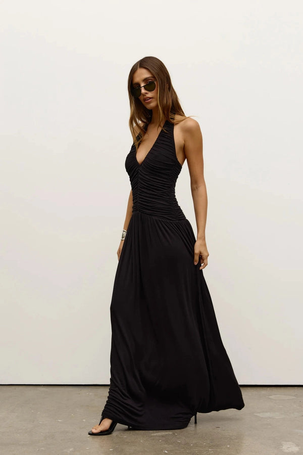 Frances Dress in Shadow by Bayse, a full-length ruched dress with a plunging halter neckline and open back for elevated evenings.